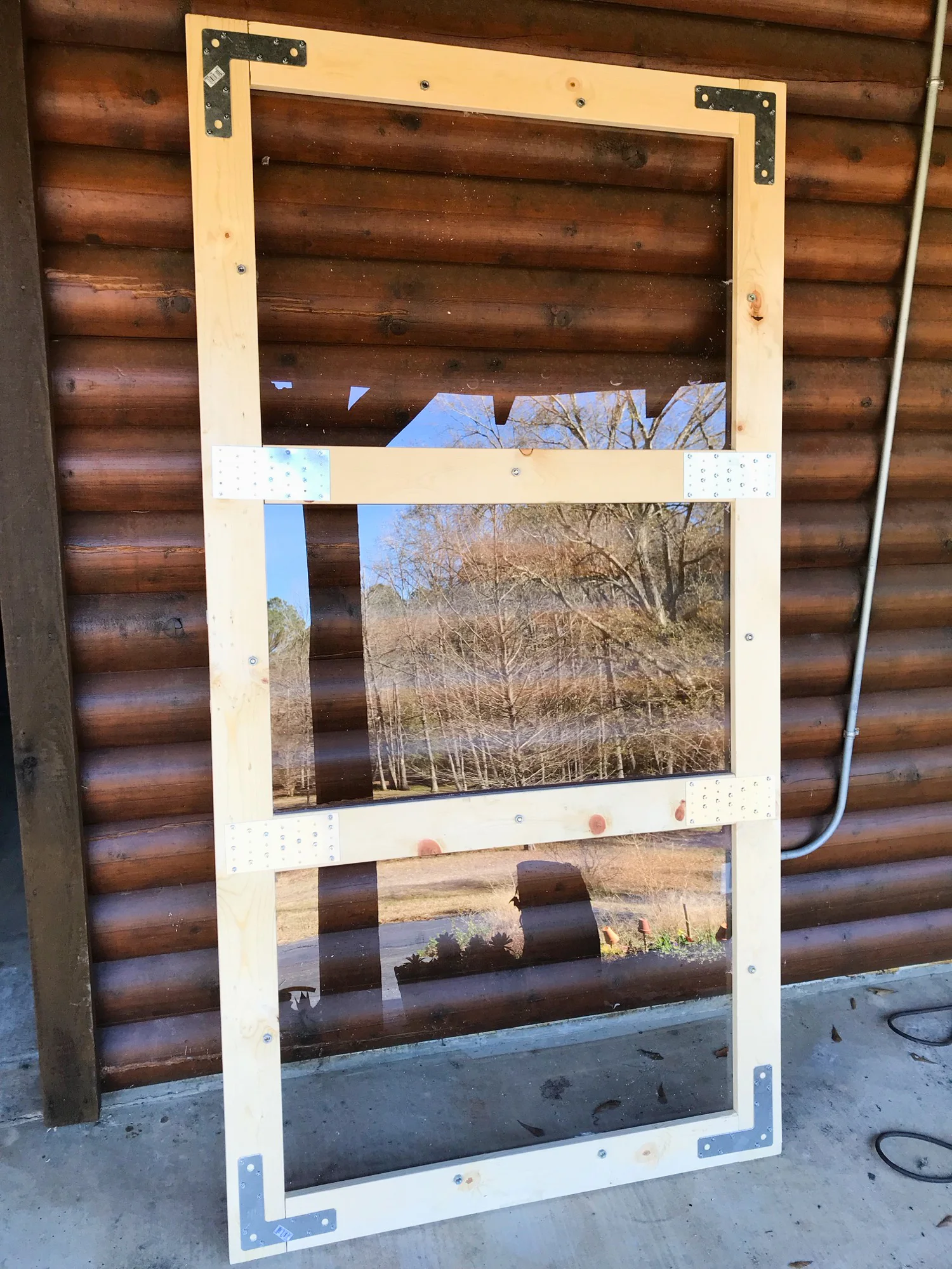 Here’s the light constructed with the plexiglass attached to the wooden frame. I used braces on the joints to make sure it stays sturdy. I used a PVC-rated drill bit and drilled slowly into the plexiglass. The guy at the hardware store told me to leave the protective coating of plastic on the glass to help drill through it. If the protective layers are absent, he said a piece of tape would help to protect the glass from shattering when drilled.