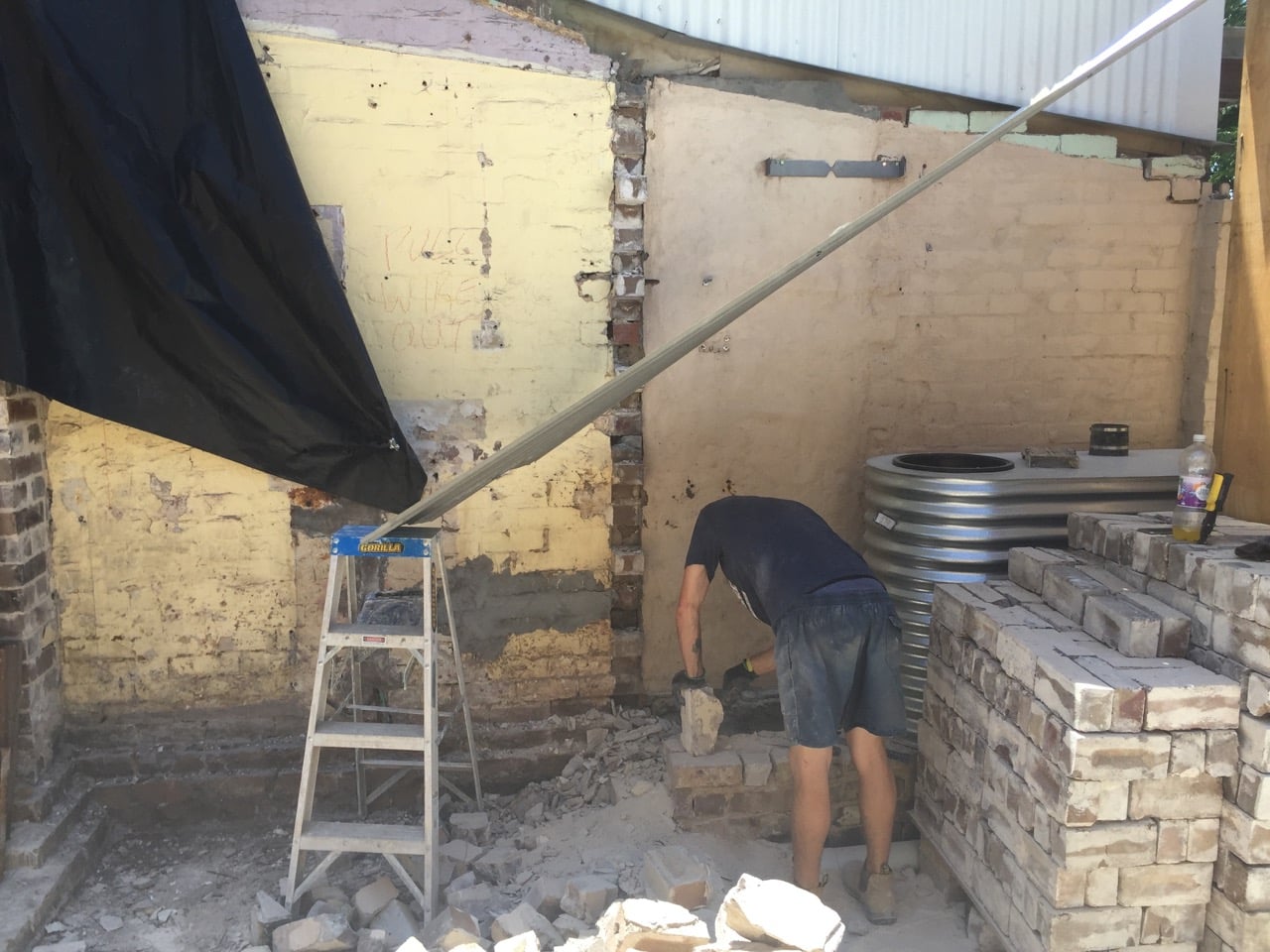 Andrew, a builder, recycling bricks and getting them ready for the bricklayer
