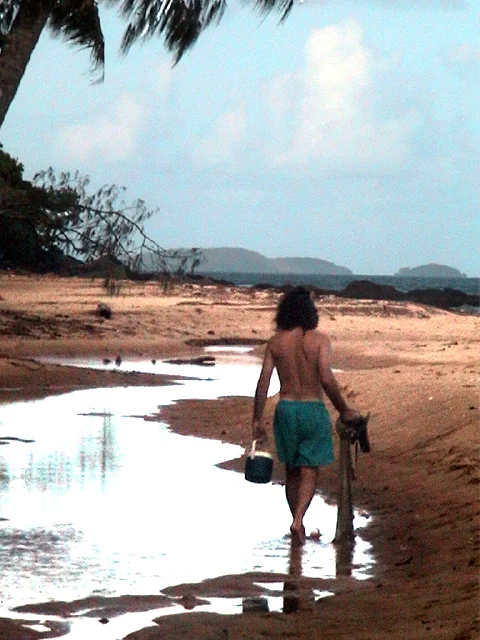 At Bingil Bay in Northern Queensland, Australia. Here I am walking up the beach at low tide after netting small fish for bait.
