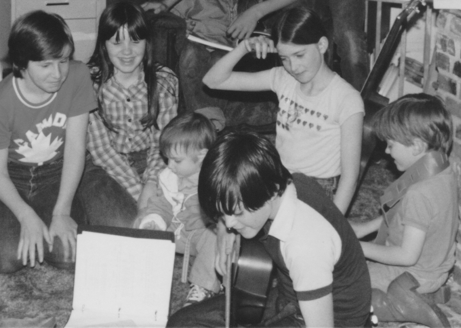 Patrick playing guitar, MacNeil Family, Ashley, Sutu, and Christopher 1981.jpeg