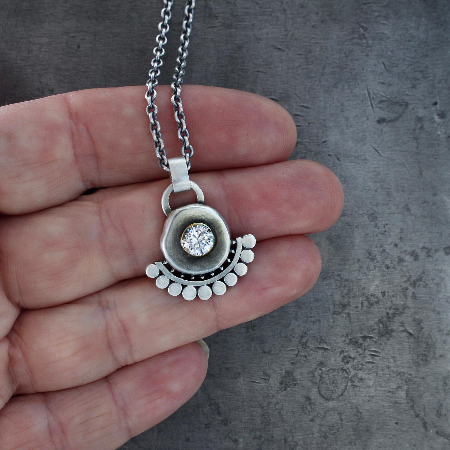 A recycled silver drop pendant with an 18k gold bezel, a spray of my sunflower motif, all centered with a lovely faceted white zircon. The contrast of the buttery warm yellow gold bezel against the patinaed silver is just so delicious!
Just listed on