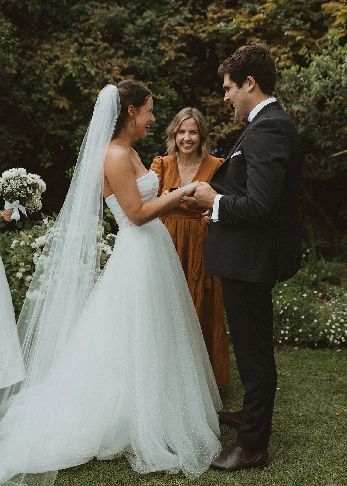 Marriage celebrant Ali officiating a ceremony in Adelaide laughing with couple