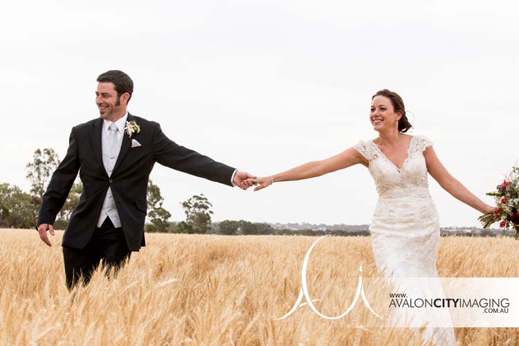 Photo of couple frolicking in paddock on wedding day
