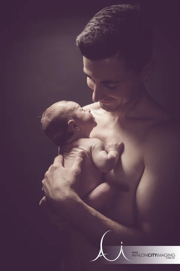 newborn photography - skin to skin contact with baby and dad with directional studio lighting.jpg