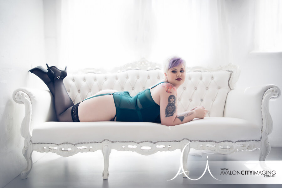 Boudoir photograph of lady in green lingerie with tattoos