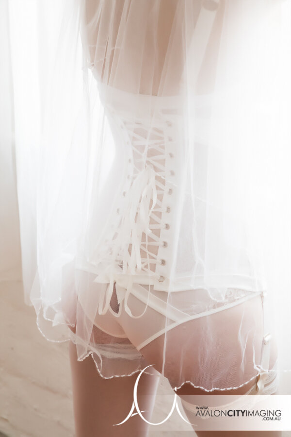 Bridal boudoir photography with white lingerie close up from behind