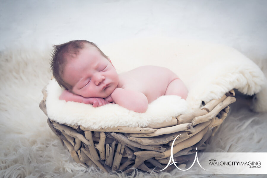 Newborn photography – baby asleep in wicker basket
