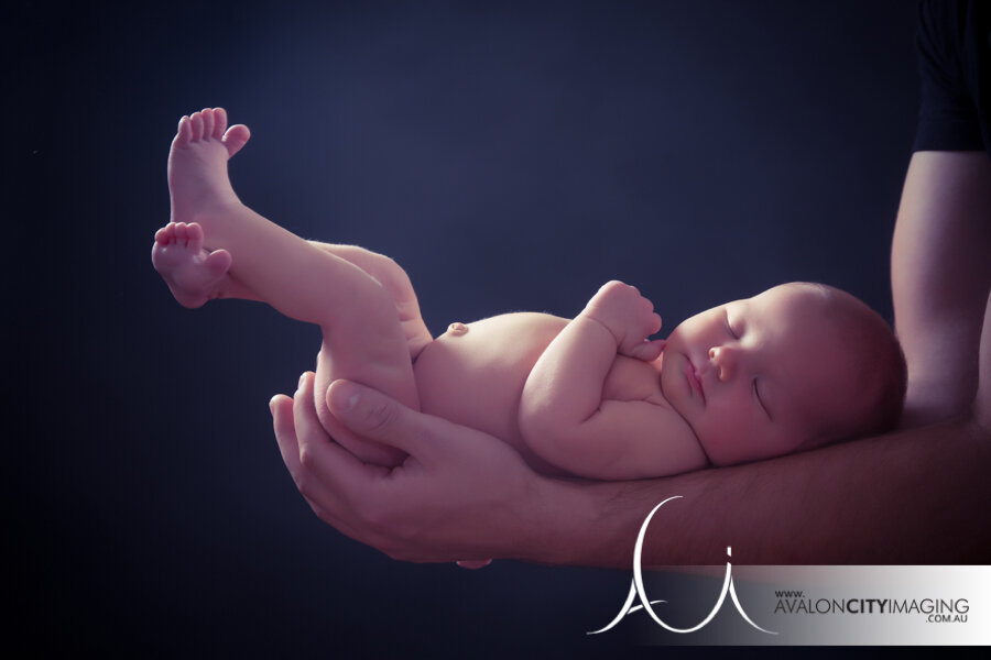 Newborn photography – father holding baby