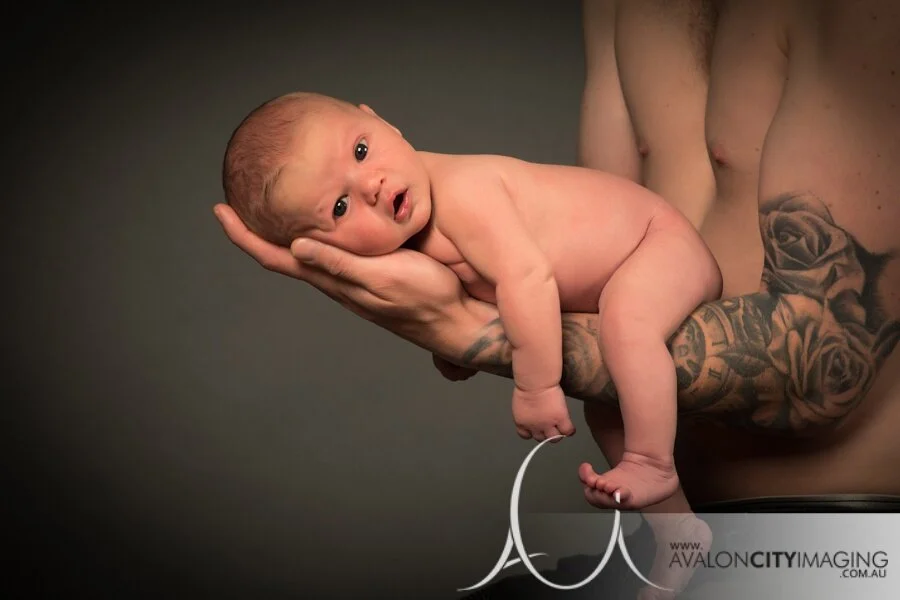 Adelaide Newborn Photography - Dads arm with tattoos holding newborn baby