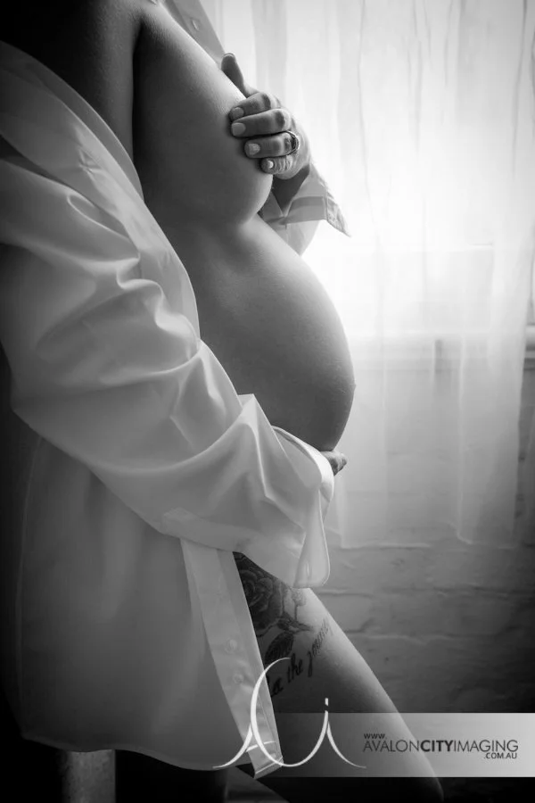 maternity photography - expecting mother holding her bump in gentle pose bw.jpg