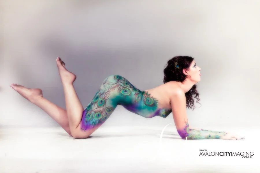 body art photography - elegantly posed woman with peacock body painting posed with a total white backdrop.jpg