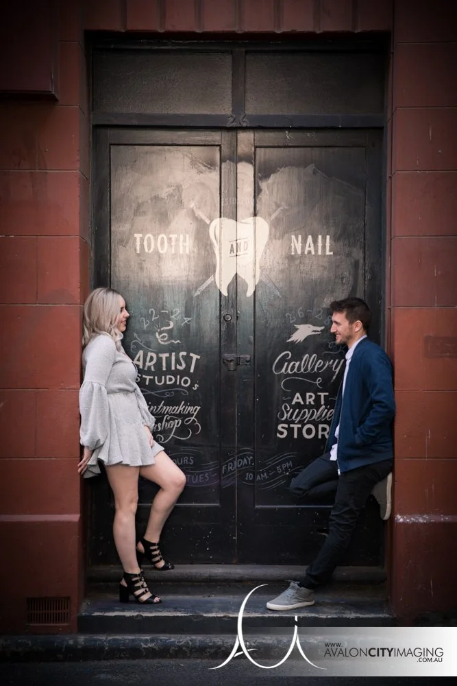 Engagement photography- couple posing relaxed in doorway outdoors with bold contrast.jpg