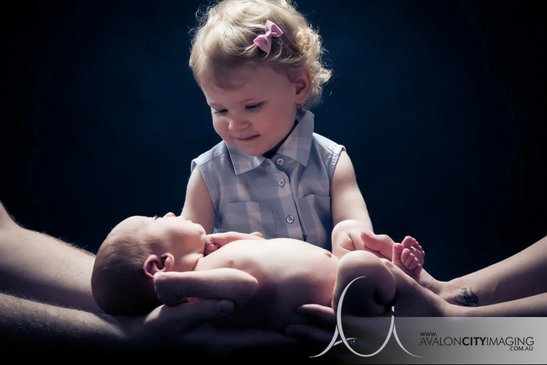 Adelaide Newborn Photography - Big sister smiling at newborn baby held by mum and dad