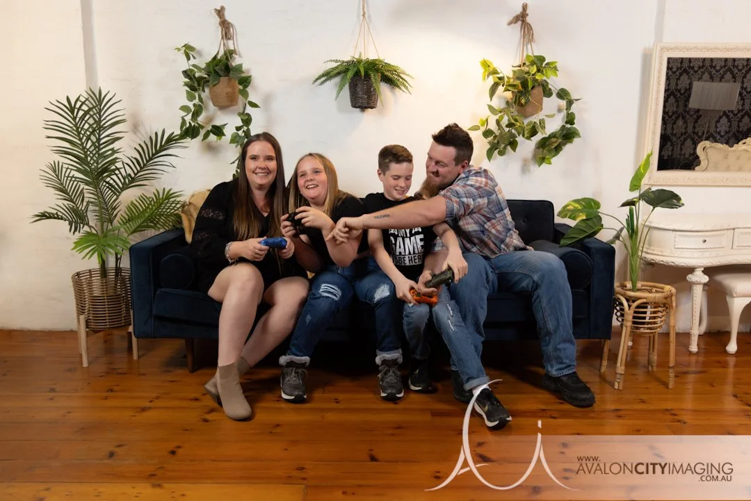 Family photography- parents with children posing in a playfully candid manner with gaming controllers.jpg