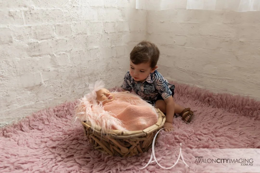 newborn photography - newborn lying beside older sibling in a gentle pose.jpg