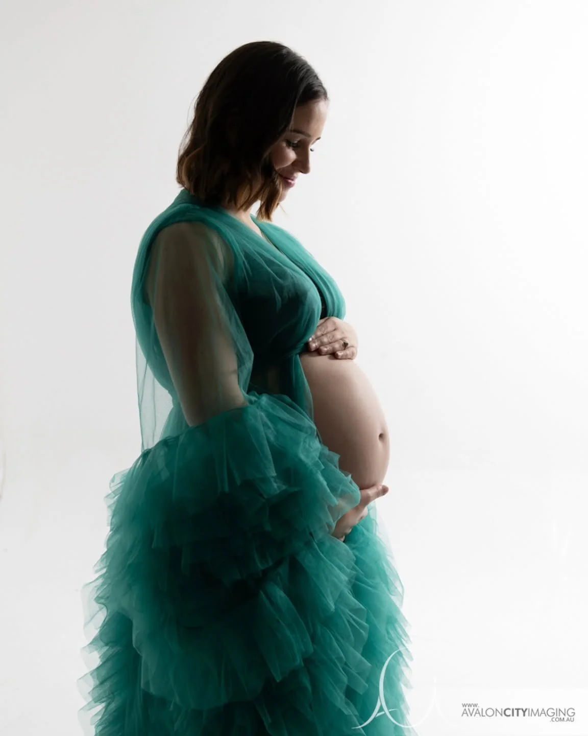 matrnity photography- mum in green maternity gown with clean backdrop.jpg