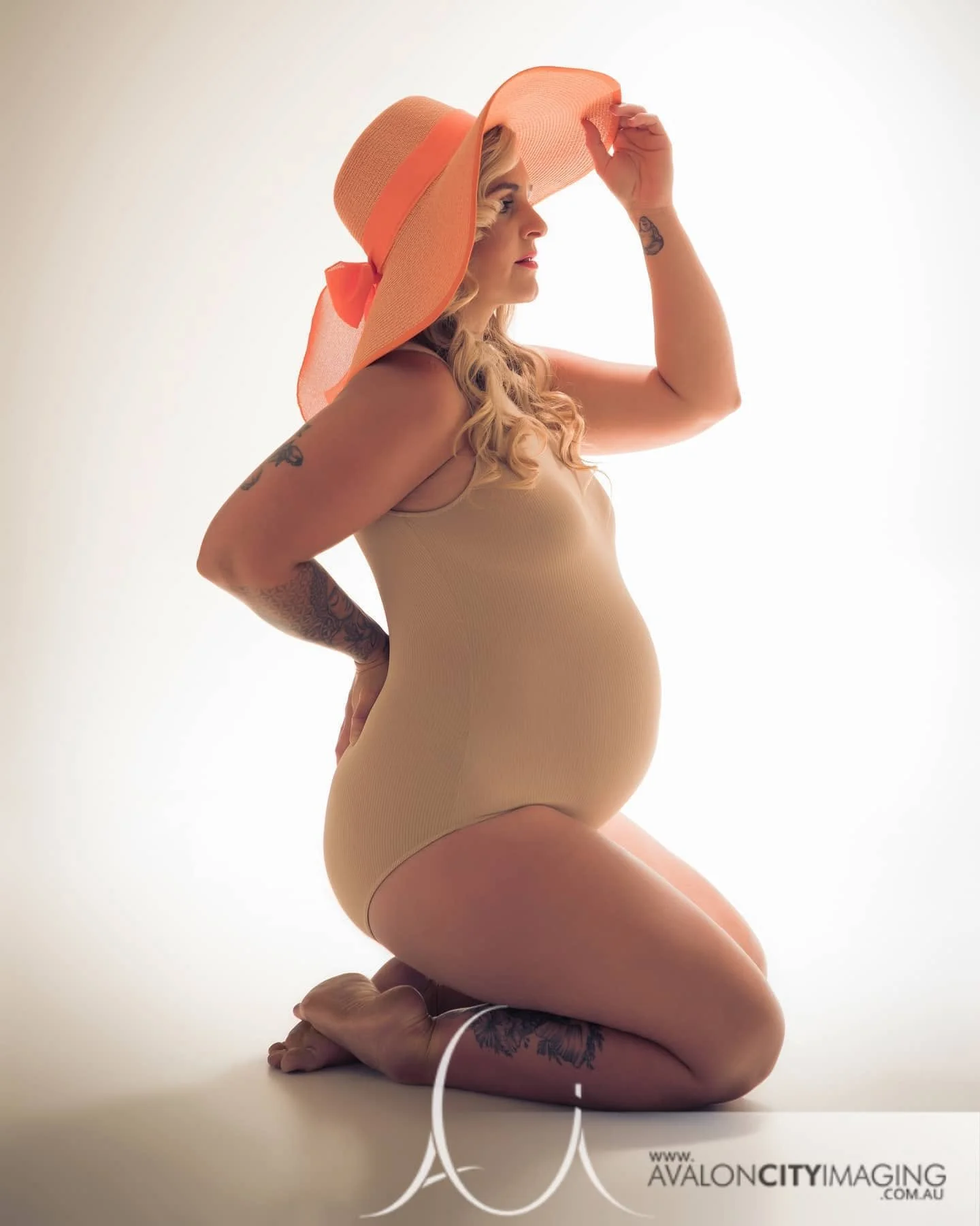 maternity photography - pregnant woman with tan bodysuit and big sun hat.jpg