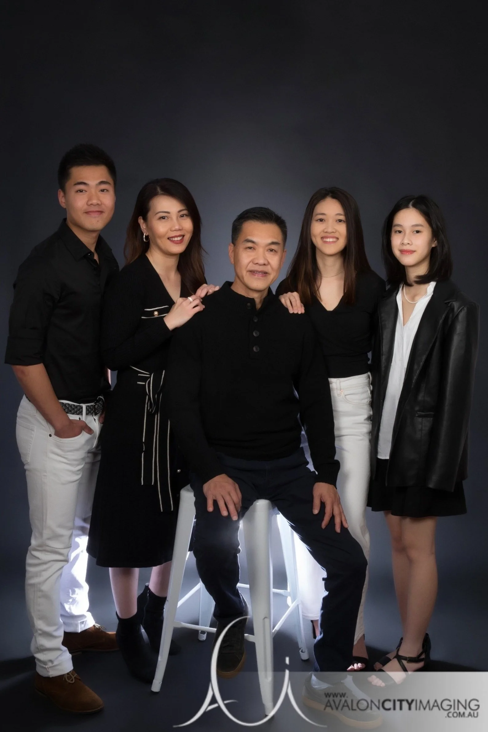 Family photography- adult siblings posed professionally with parents in studio.jpg