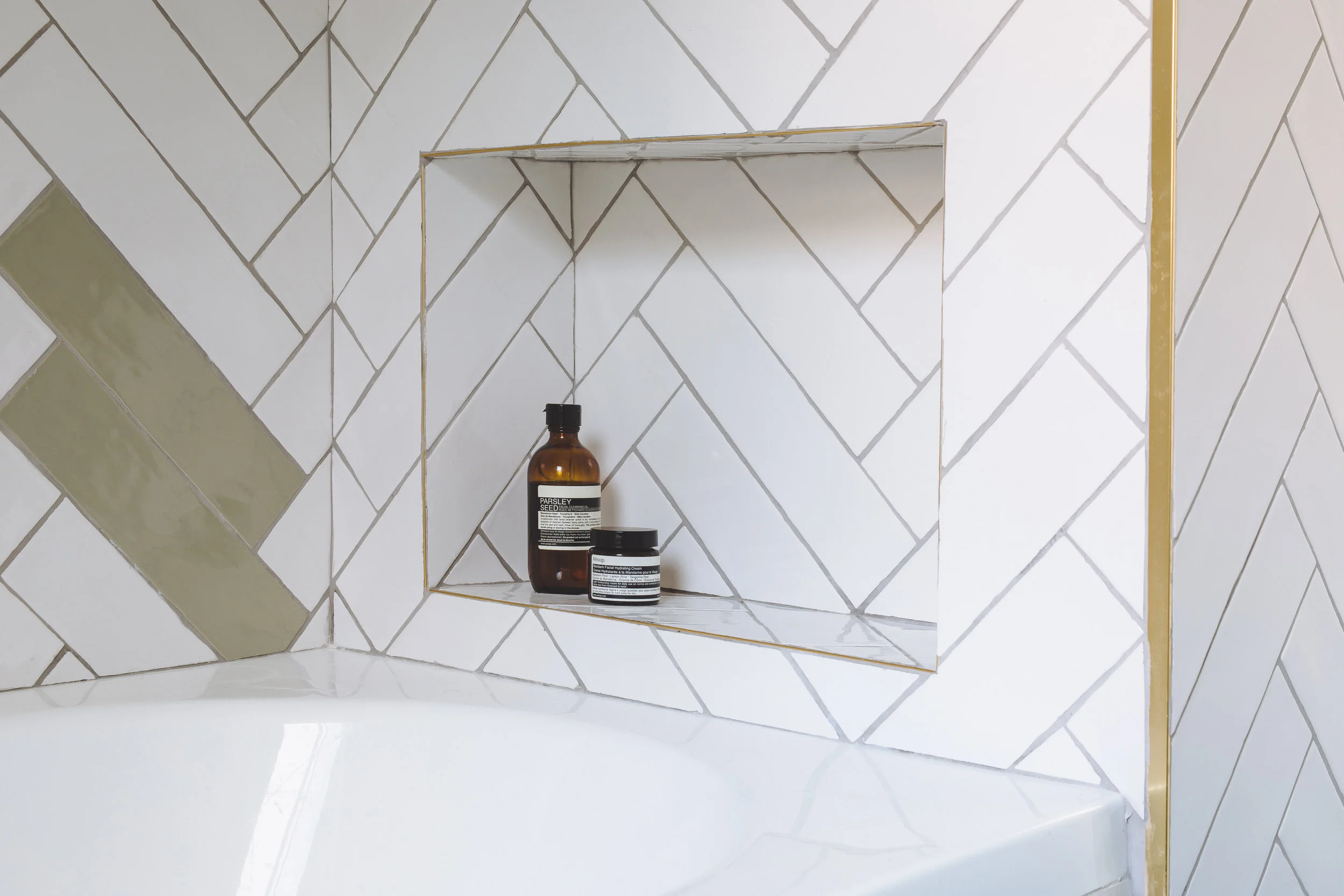 Bathroom subway tiles in fishbone. Brass details