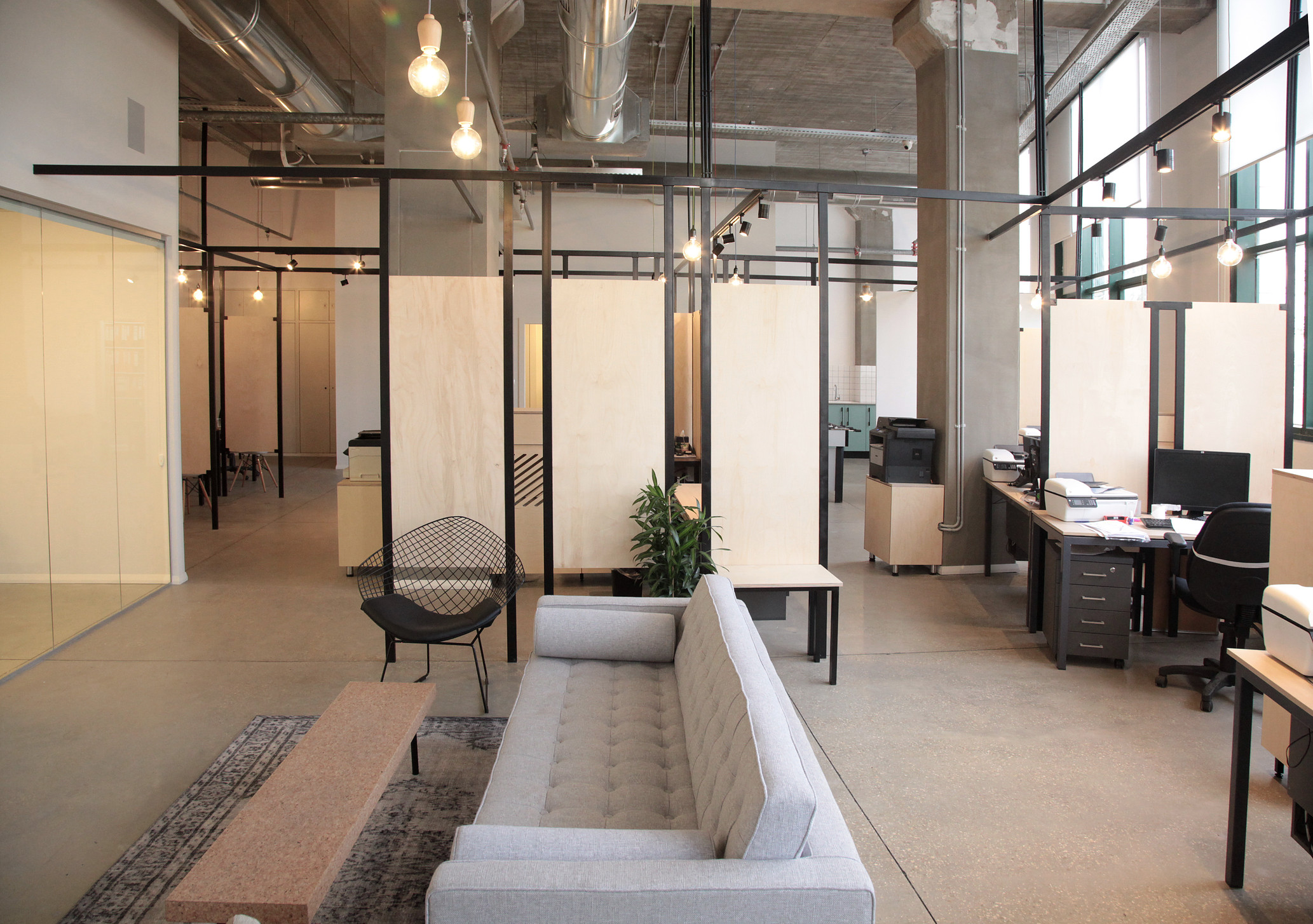 Office waiting area. concrete ceiling& floor. grid construction made of steel. wood dividers
