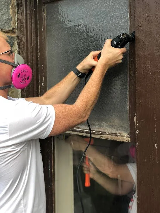 One of our Ralliers removing a vintage wood window from its opening.