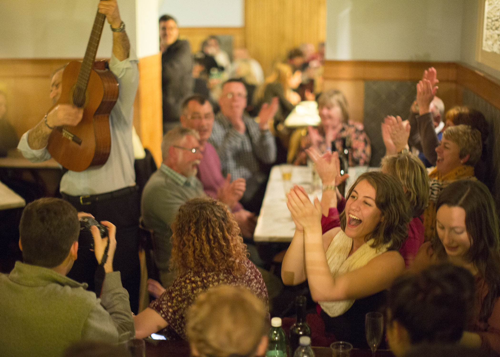 Students interacting with locals and enjoying a musical performer in a neighborhood restaurant in Naples, Italy (photo: Canisius College)