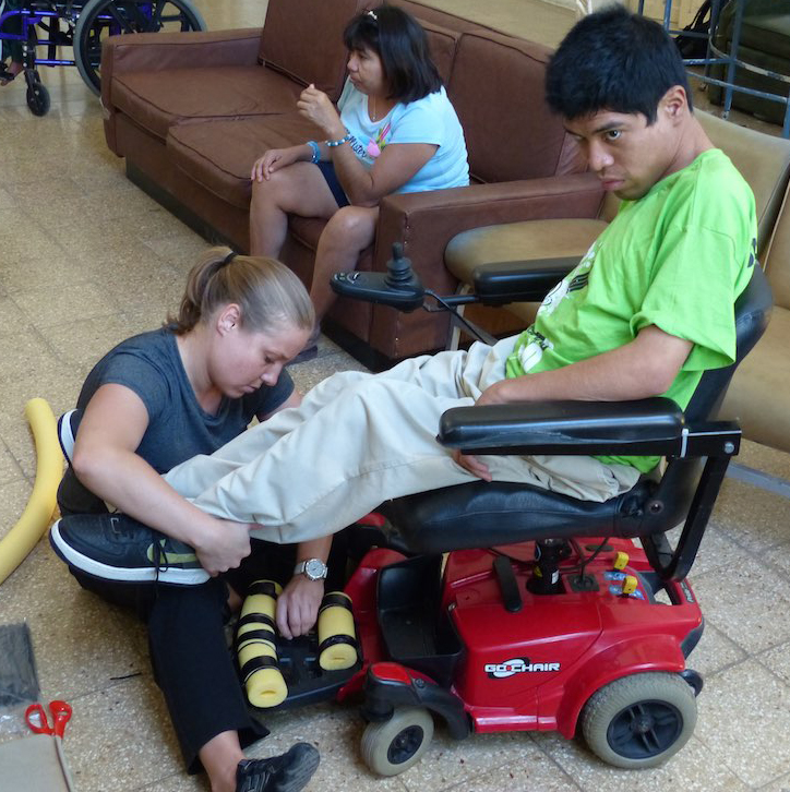 Above: A handicapped man from Merida gets physical therapy instructions from Wheeling Jesuit University student Christy Shaneyfelt. (Photo courtesy of Wheeling Jesuit University)