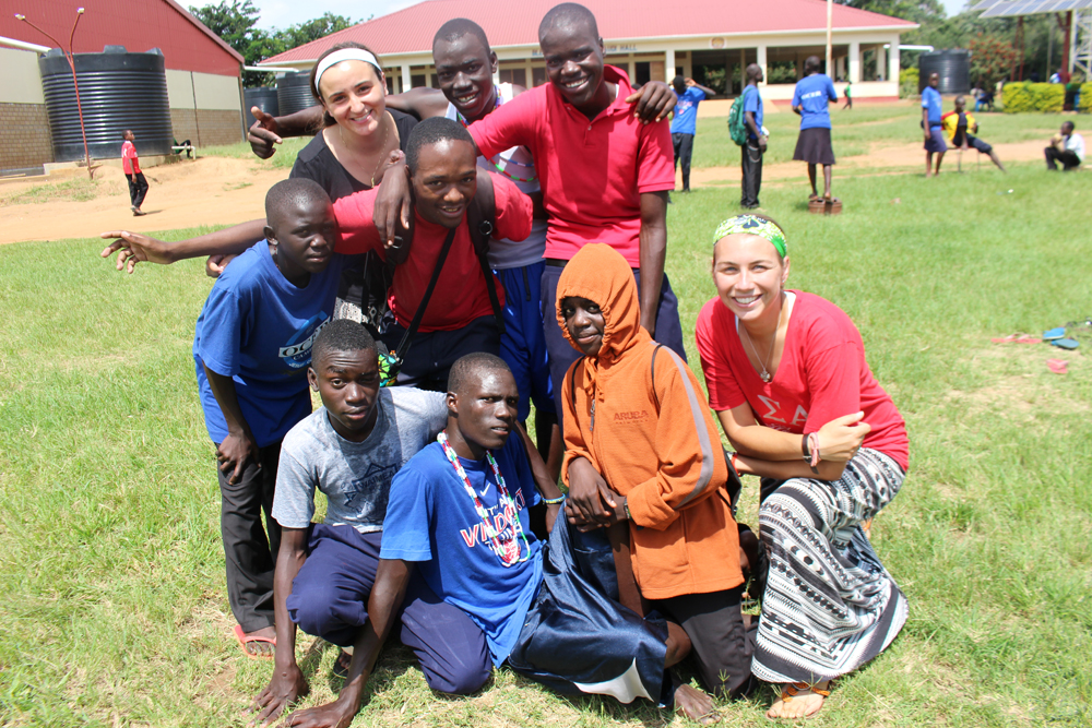 Rockhurst University junior Haley Mathews, top left, and 2014 Rockhurst graduate Melissa Hopfinger, lower right, pose for a photo with students from Ocer Campion Jesuit College in Gulu, Uganda. (Photo courtesy of Rockhurst University)