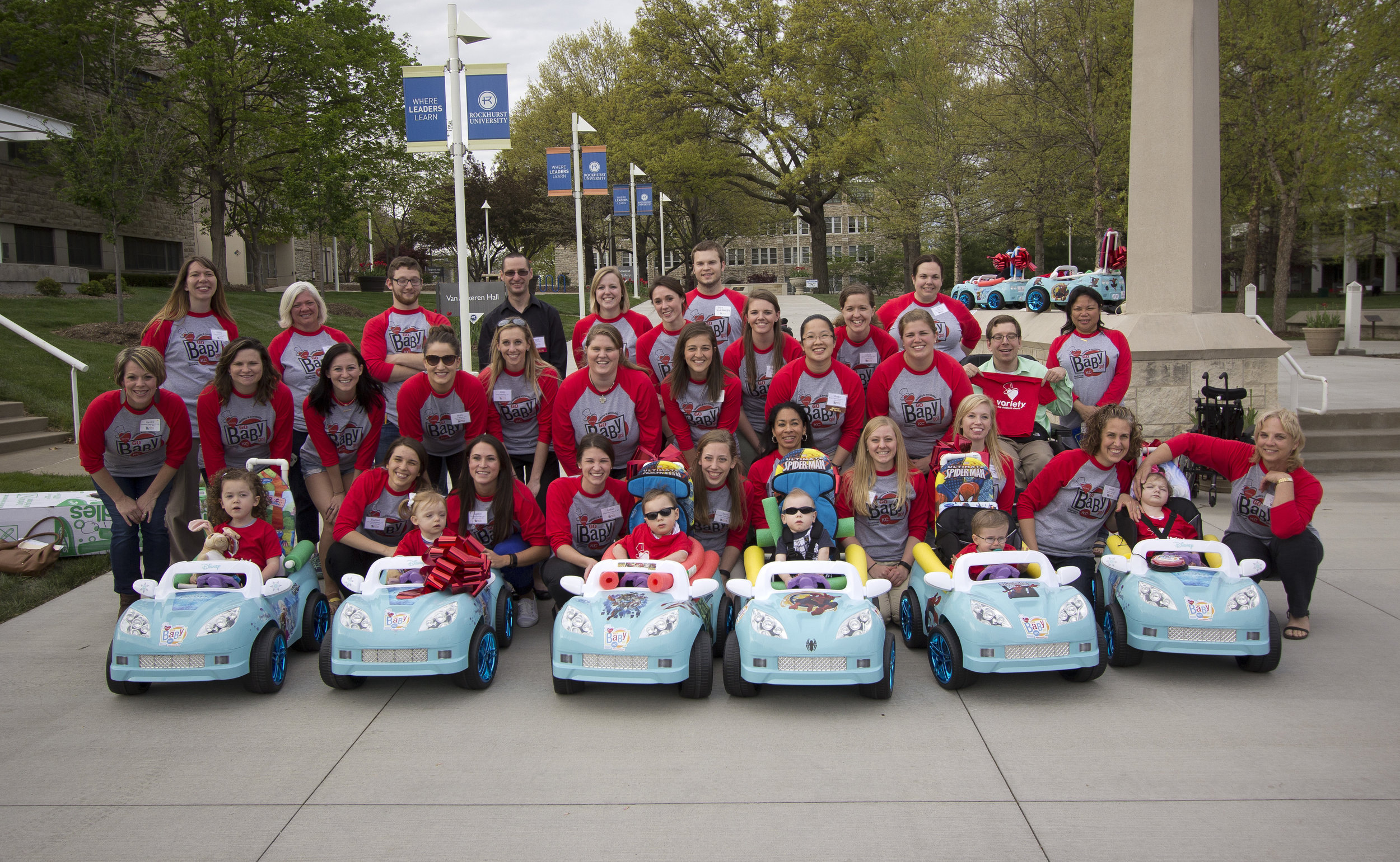 Volunteers with Variety KC GoBabyGo! Powered by Rockhurst University pose with children receiving their new mobility vehicles at an April 2016 event on the University campus (Photo by Rockhurst University)