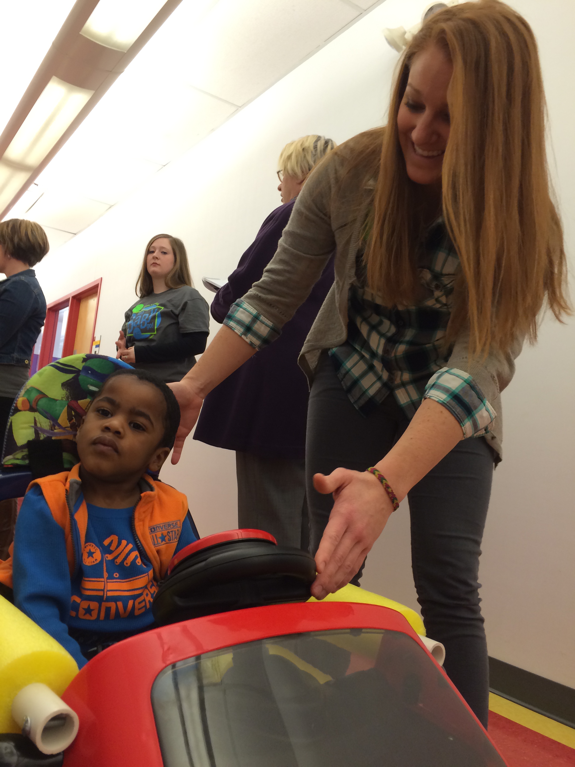 Trace Bales test drives his GoBabyGo! car with help from Rockhurst University physical therapy student Mallory White in March 2015 at the Children's Center for the Visually Impaired in Kansas City, MO. (Photo by Rockhurst University)