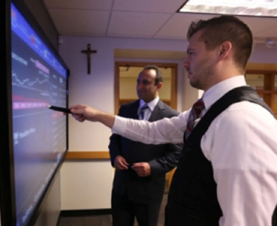 Dr. Omid Sabbaghi (left), a faculty member of the College of Business Administration, works with a Detroit Mercy student in the College's Financial Markets Lab (Photo by University of Detroit Mercy)
