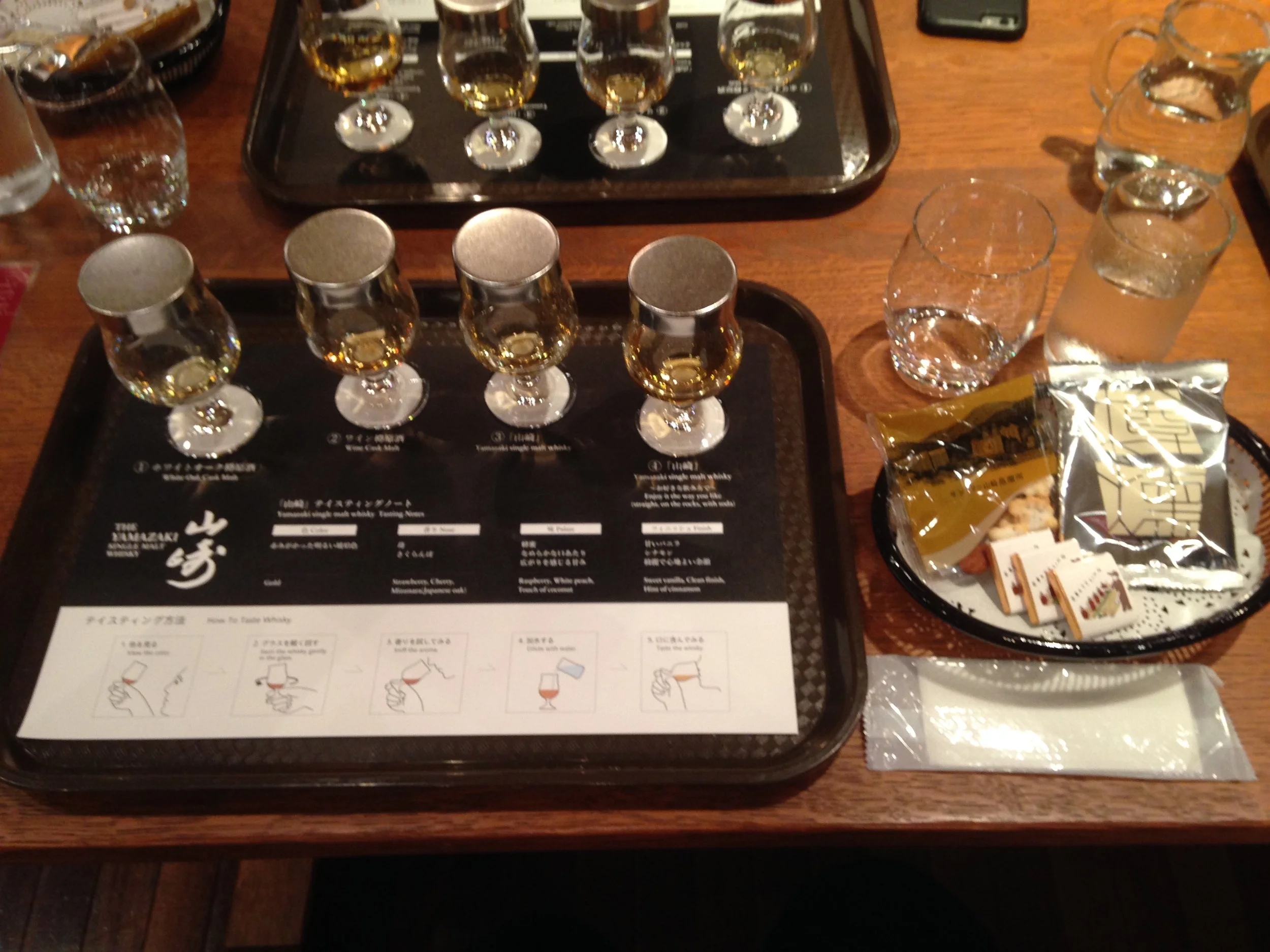 4 different whiskey tasting of different types and flavors with snacks and other treats on the side. Some of which include the White Oak Cask Malt , the Wine Cask Malt and the Yamazaki Single Malt Whiskey .