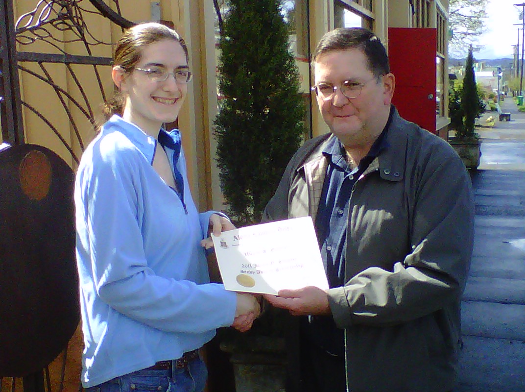 university of portland student, valerie schiller, receiving an alpha lambda delta award from former ald president and advisor, Dr. james stemler