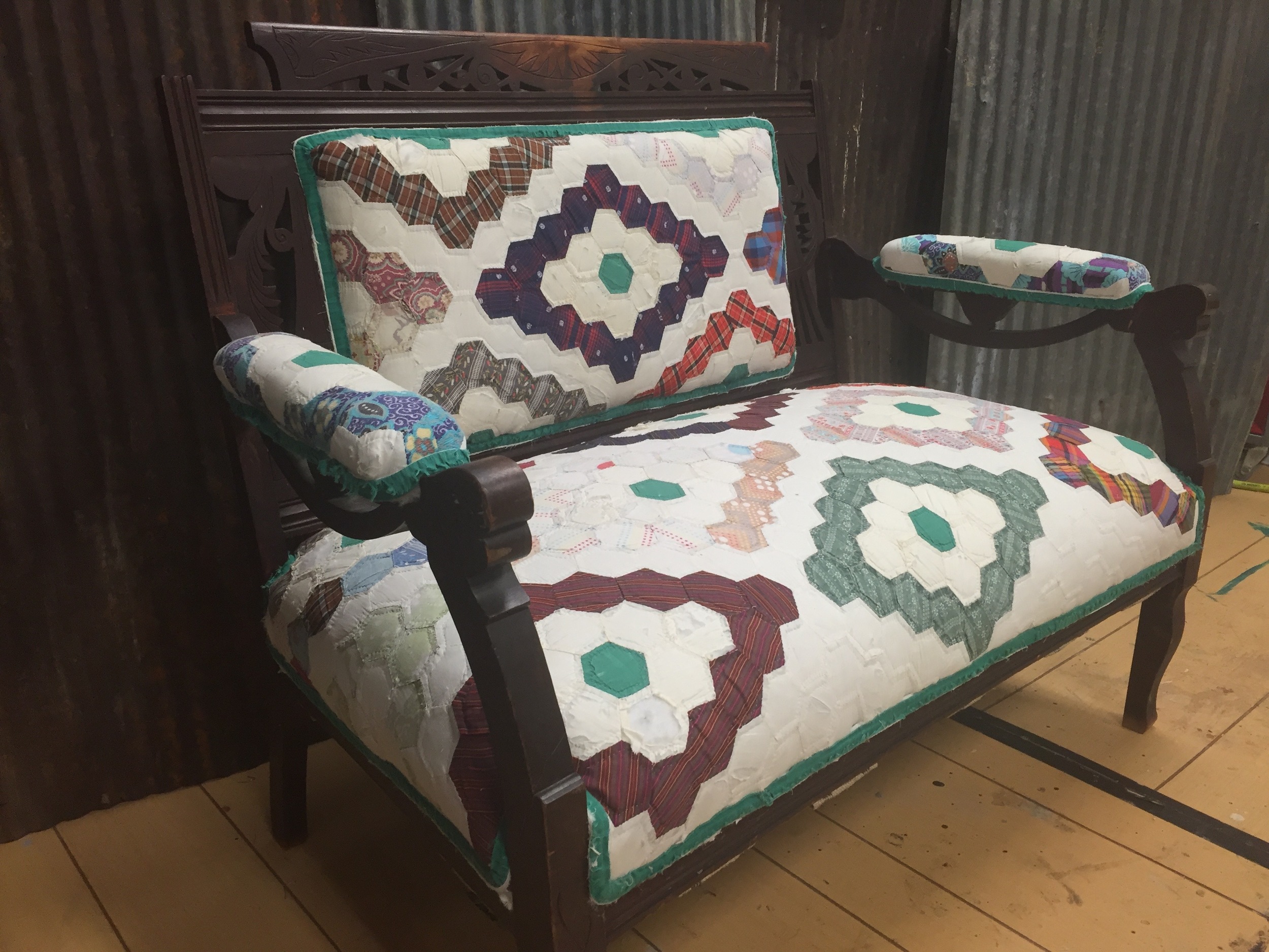    Laura Locke of Turning Leaf Crafts repurposed a vintage quilt into a unique covering for an antique settee. The quilt donated by musician Sheryl Crow will be auction off at the June City Farmhouse Pop-up Fair. The proceeds from the auction will be