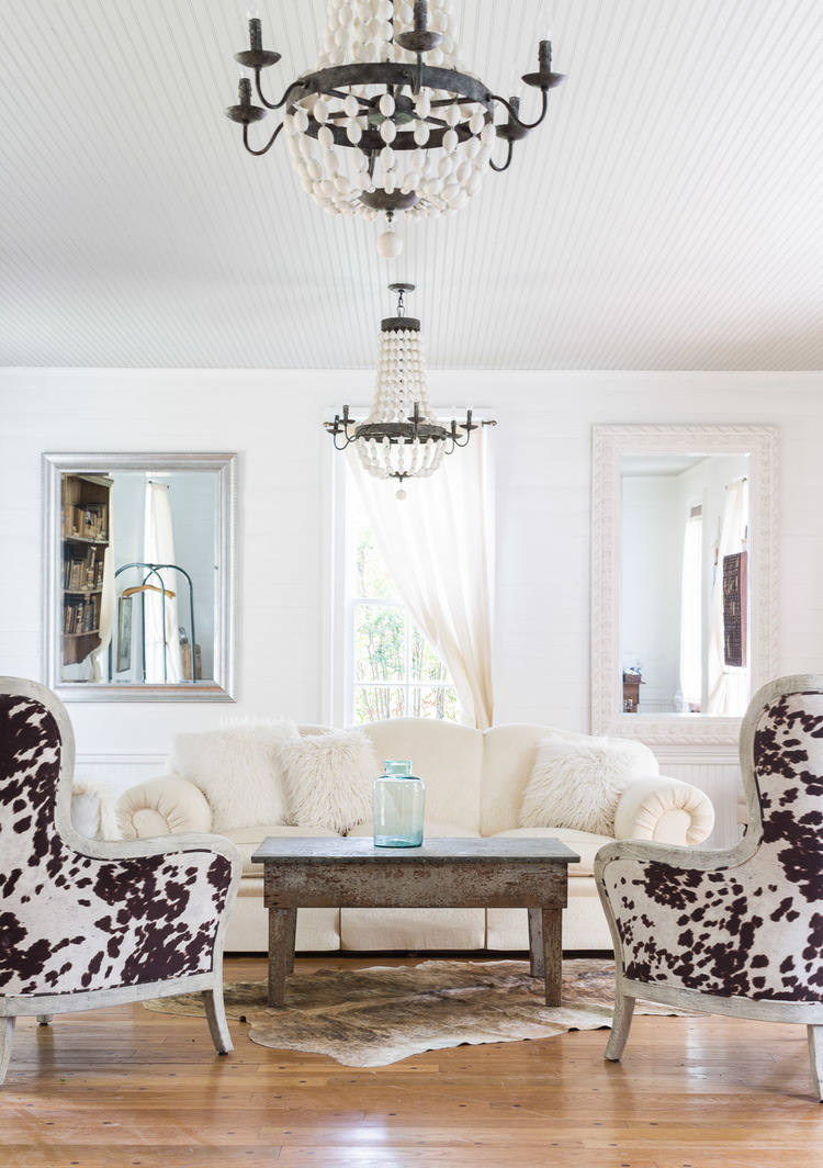 Decorated in Modern Farmhouse Style boasting antique chandeliers, cowhide covered chairs, and other antique furnishings. Interior Design: Kim Leggett, City Farmhouse