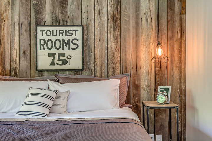 "Tourist Rooms 75 cents" sign hangs in the bedroom at the Nest | Interior Designer: Kim Leggett