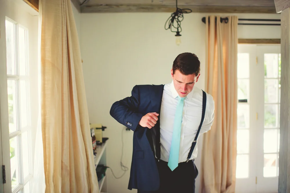 ocean view club wedding : groom putting on jacket