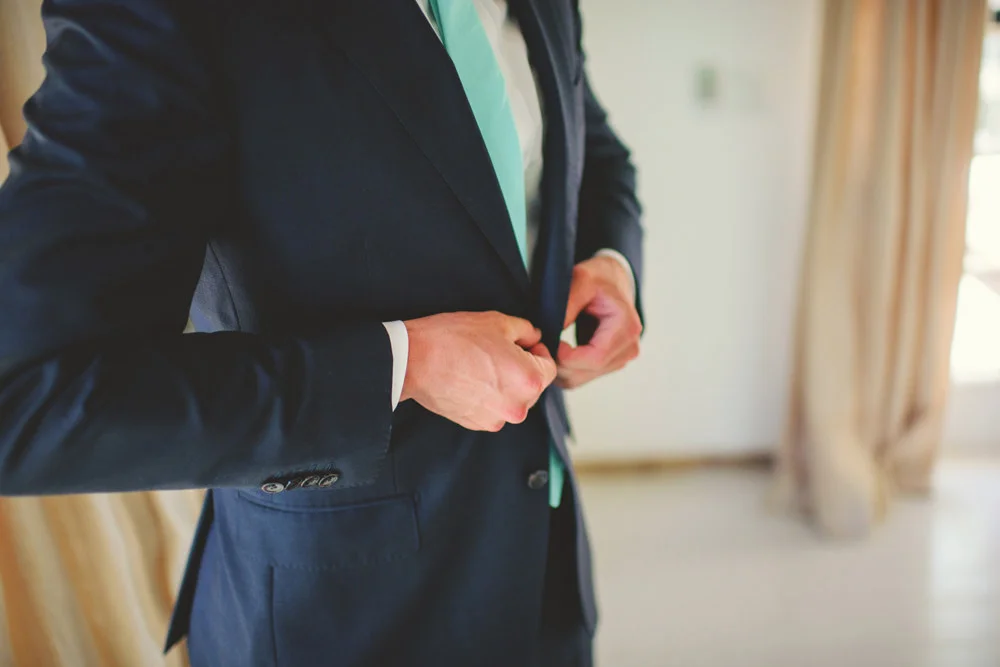 ocean view club wedding : groom buttoning jacket