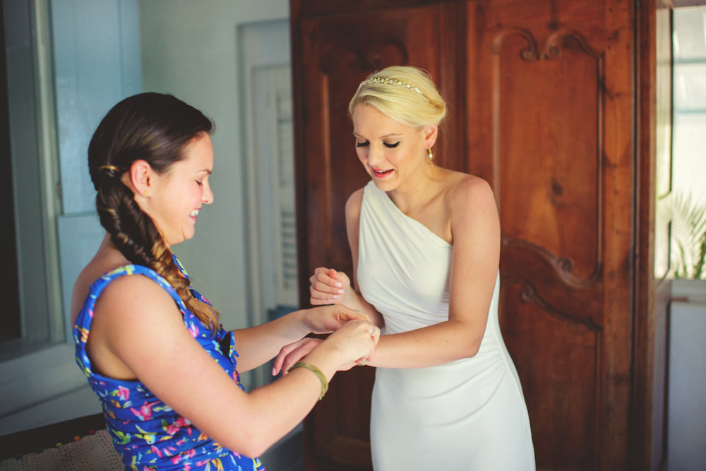 ocean view club wedding : bridesmaid helping with bracelet