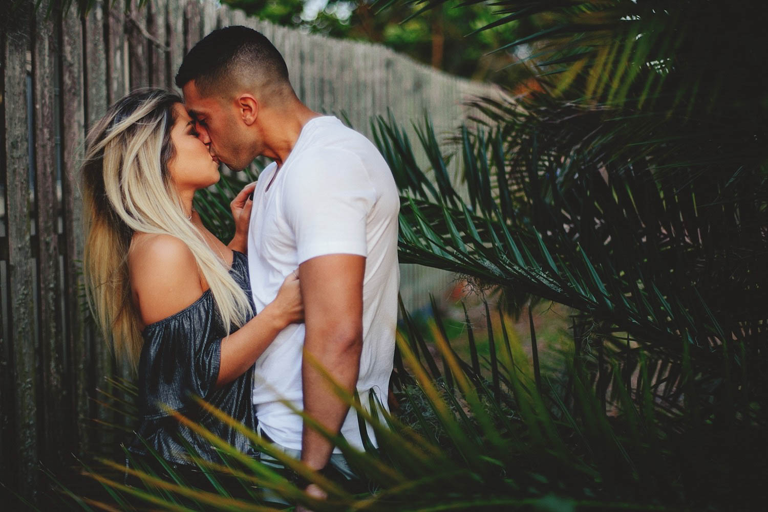winter garden engagement photos: kissing in the bushes