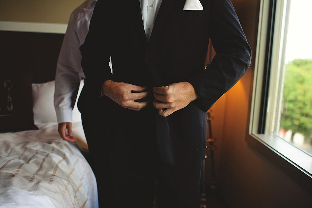 groom buttoning jacket