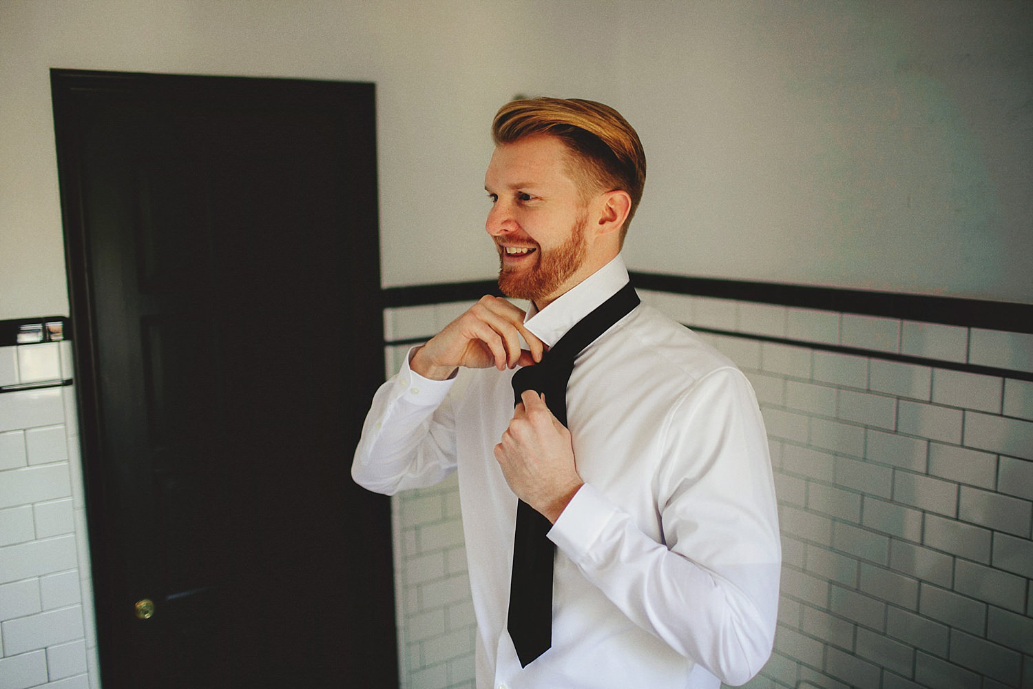 casa feliz wedding photos: groom putting on tie