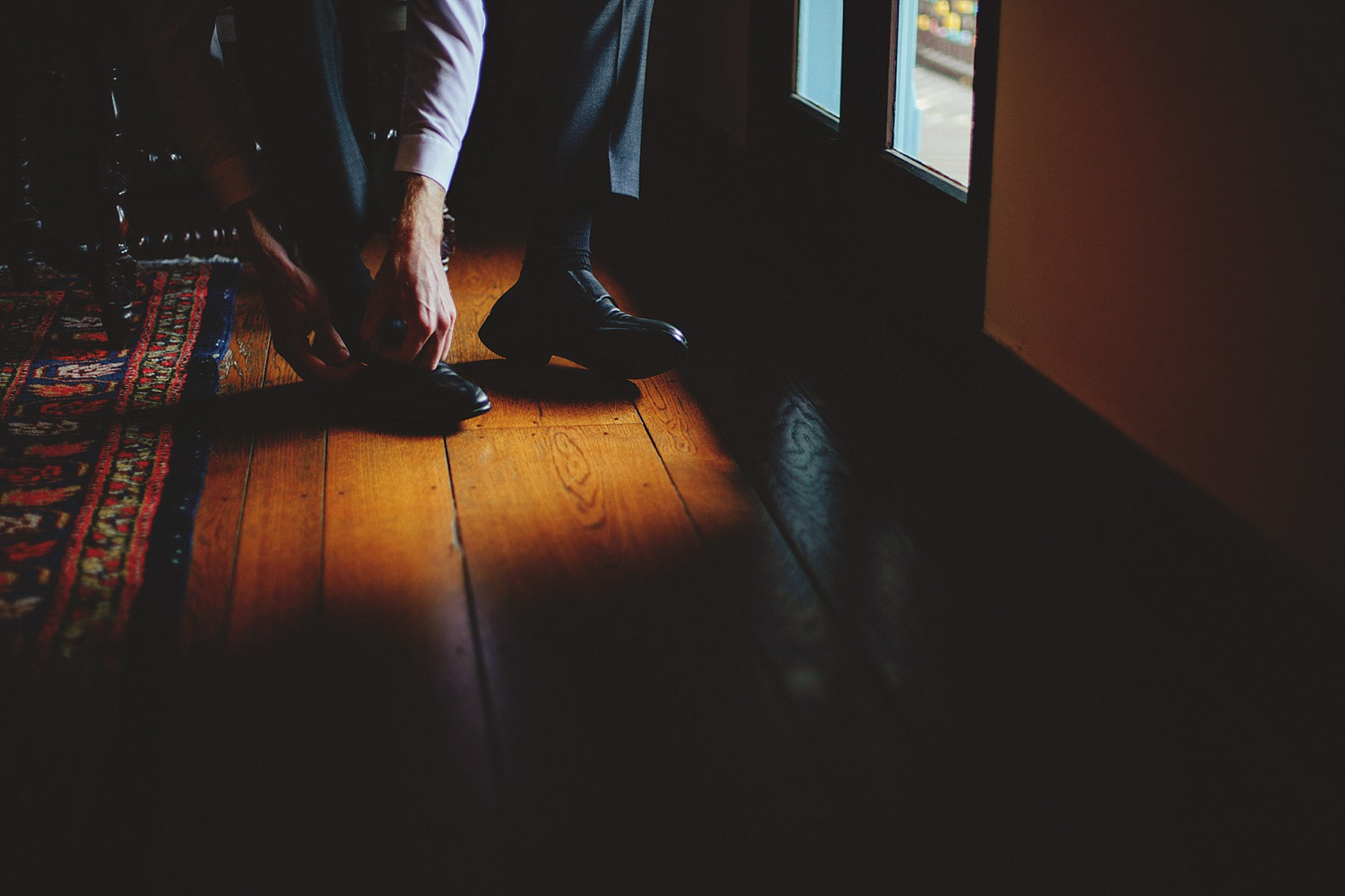 casa feliz wedding photos: groom putting on shoes