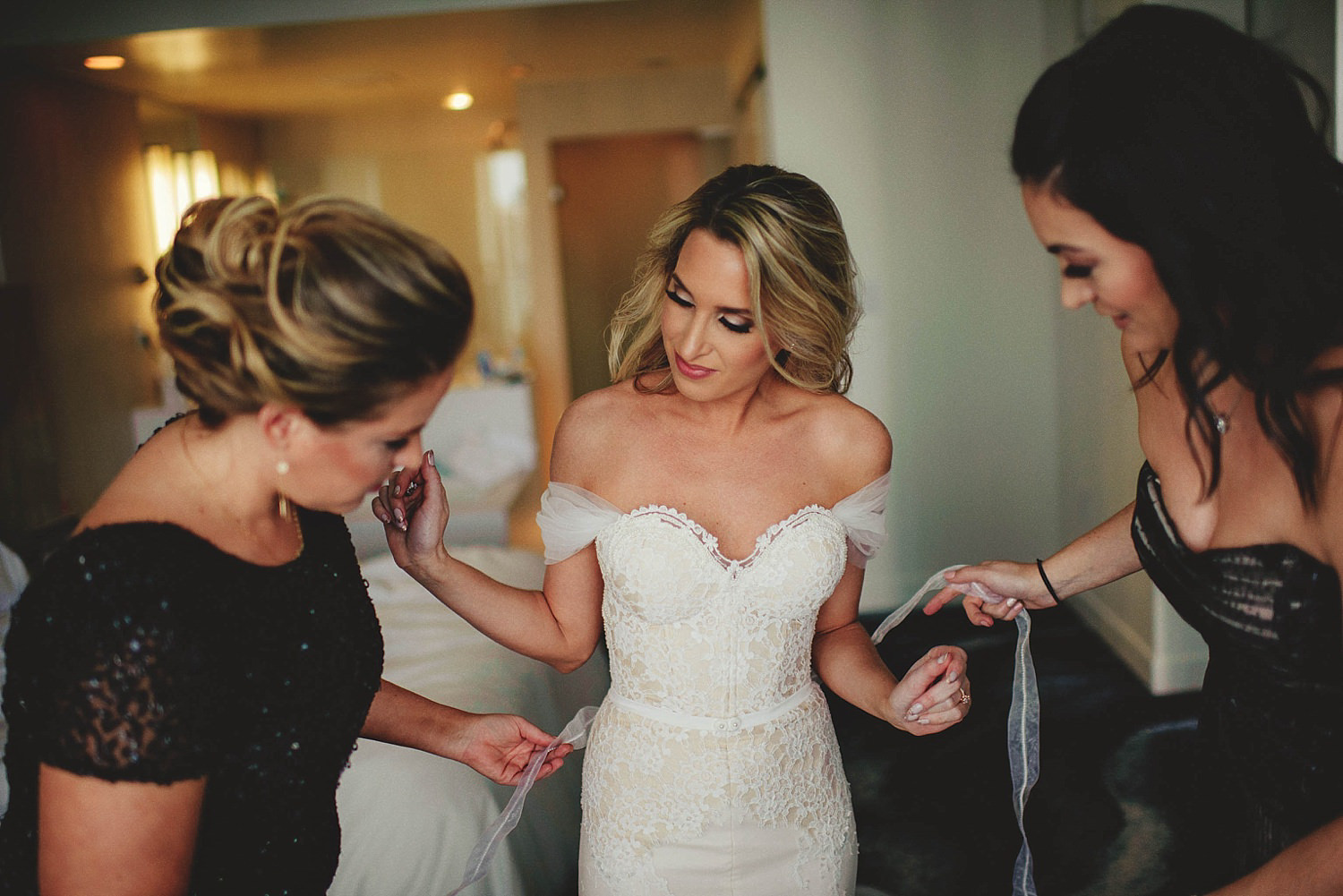 bridesmiads helping bride with dress