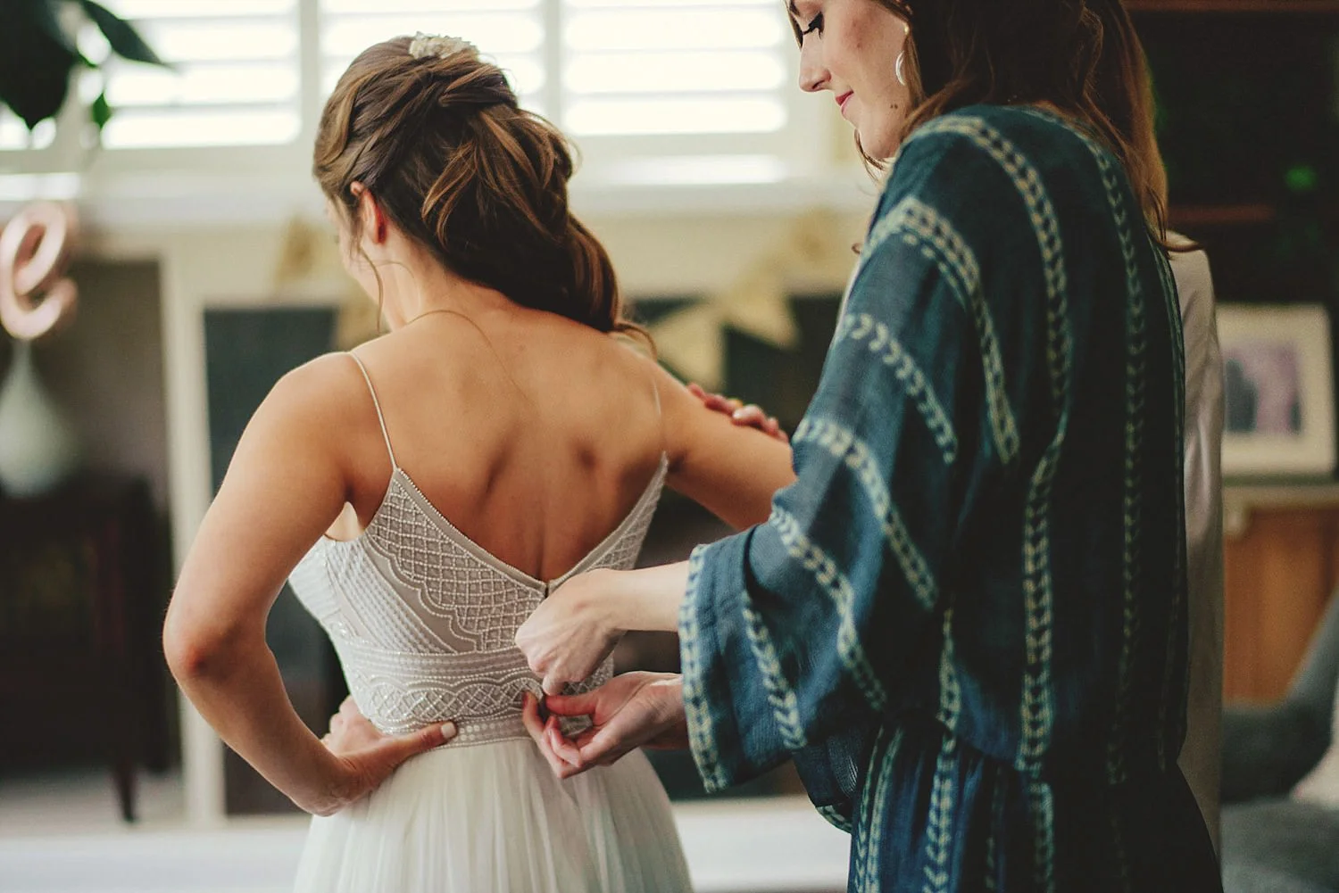 knowles memorial chapel wedding: maid of honor zipping up weddin
