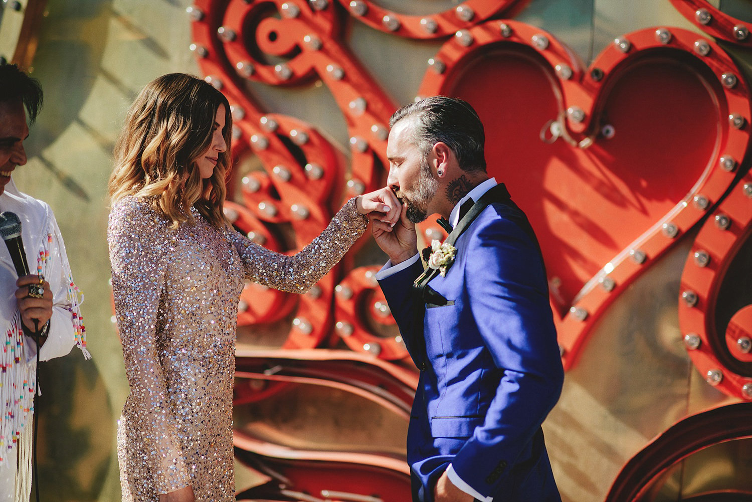 neon museum wedding - groom kissing hand