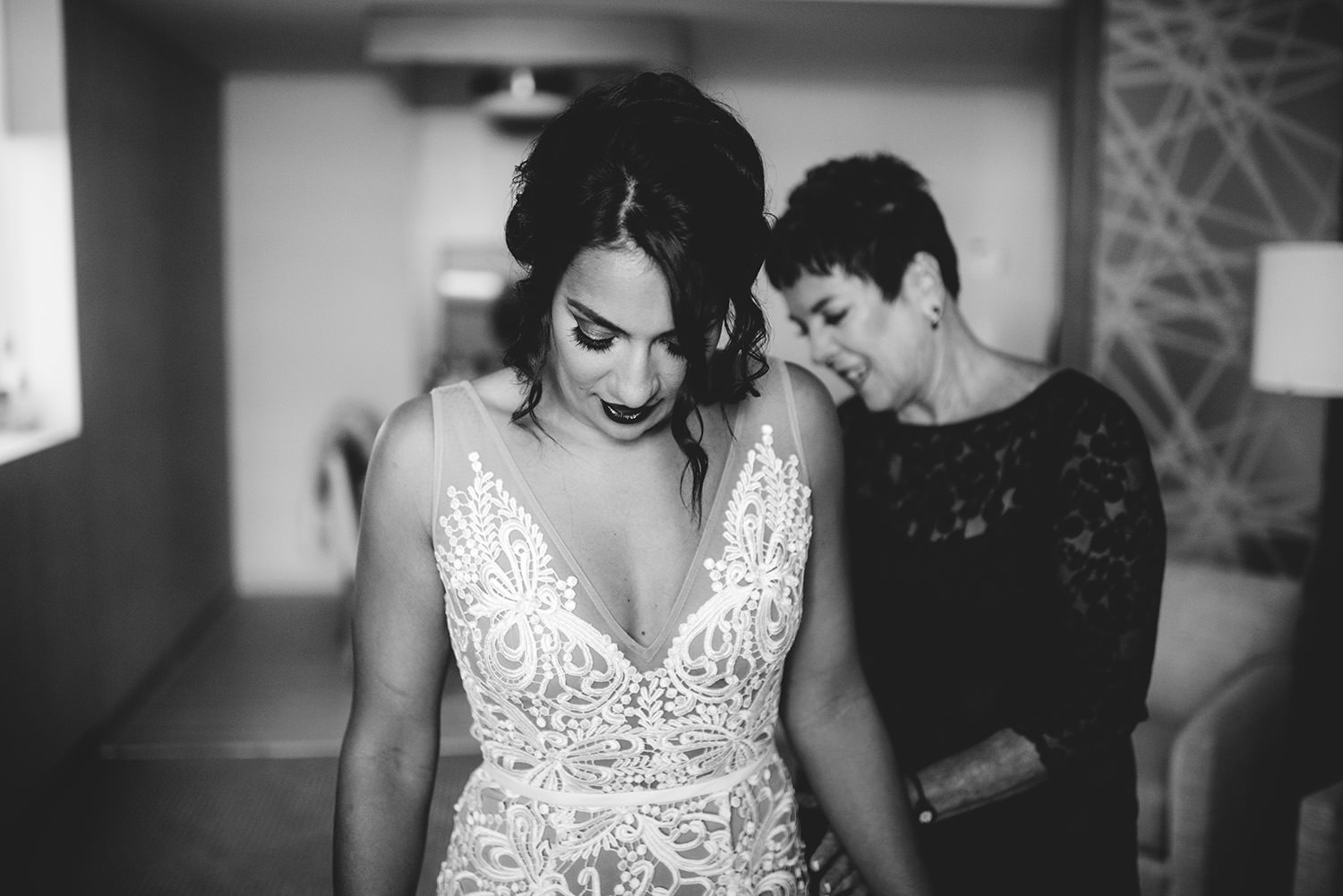 mom zipping up wedding dress