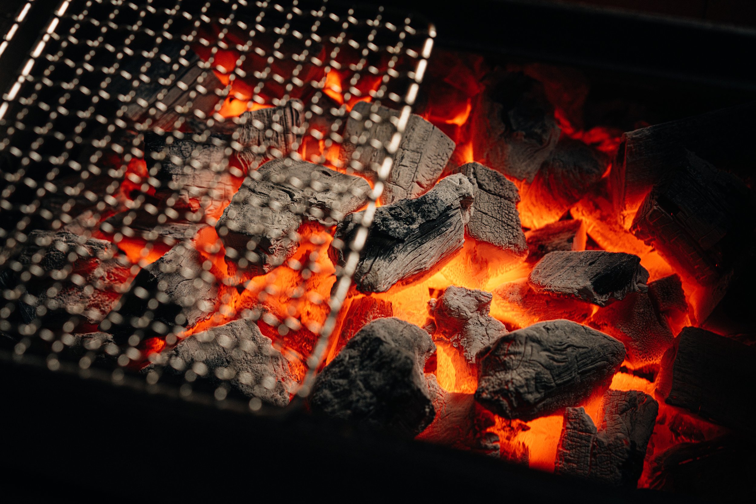 Brightly burning Benu charcoal in the grill.