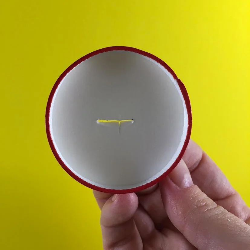 use a base de um copo de papel para fazer o pé da boneca, isso vai permitir que ela fique em pé na mesa.
