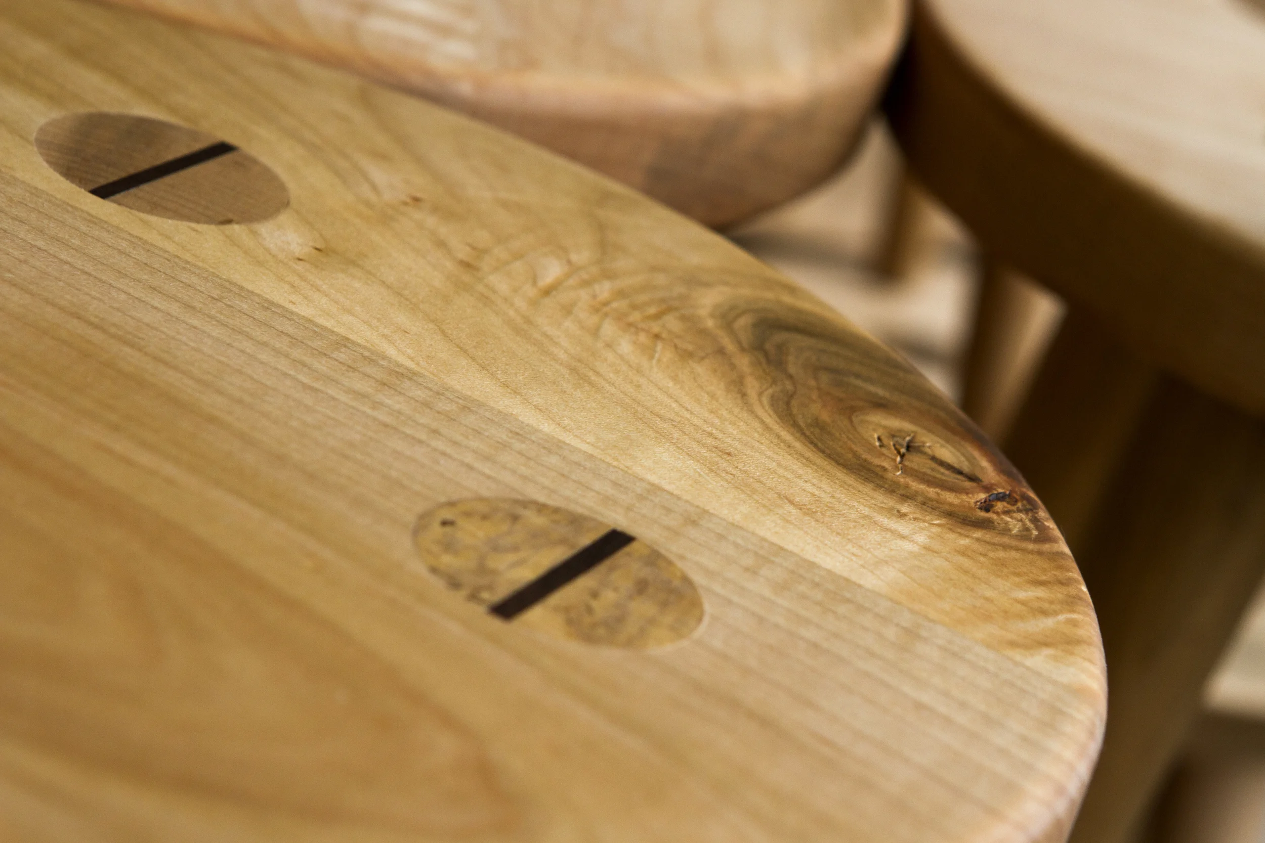 Top detail of custom designed Shaker-style maple display stools with wedged through tenon legs.